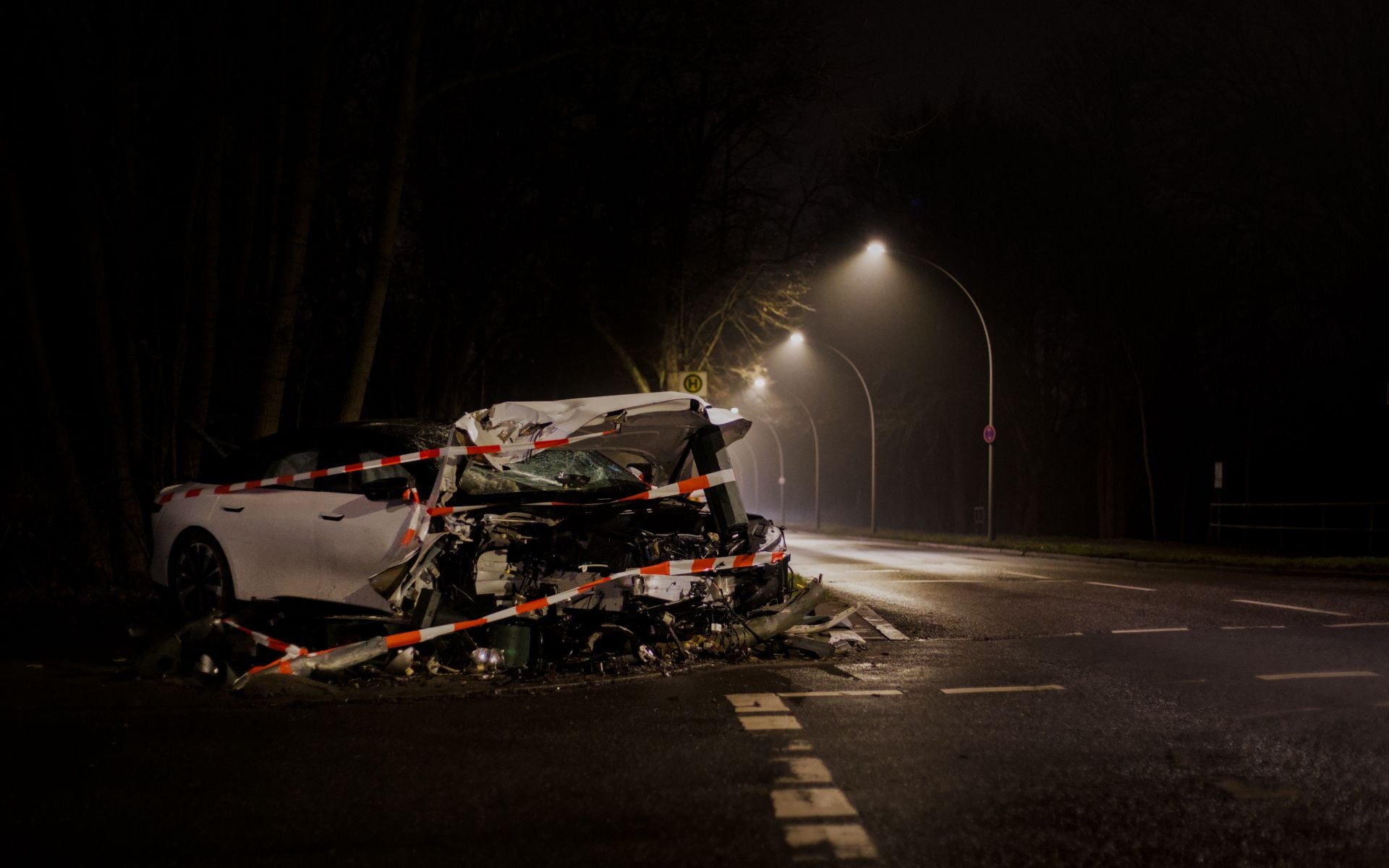 A wrecked car after a crash on a dimly lit street