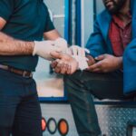 Paramedic offers first aid to an injured person near an ambulance