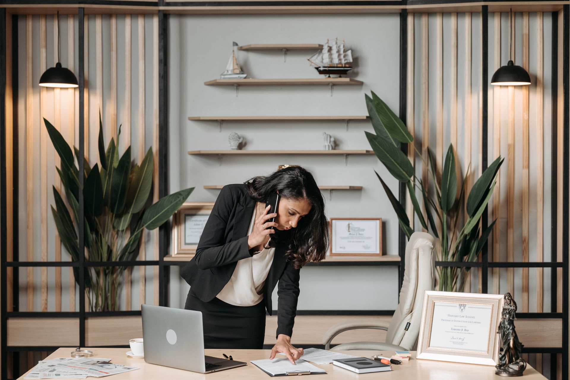 A professional woman lawyer multitasking in a modern office environment, reviewing documents