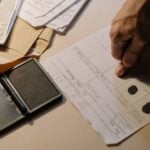 Can Federal Criminal Records Be Expunged? Why State Sealing Laws Never Reach Them 6 Detailed view of a hand taking fingerprints on a document with ink pad on desk