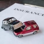 Toy car in an accident with insurance written in the background