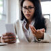 Guessing Game 8 Selective focus of displeased businesswoman using smartphone