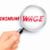 minimum wage words showing through a magnifying glass held by hand