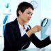 Photo of pretty businesswoman looking at paper through spyglass for workplace investigations