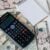 Calculator and notepad placed on USA dollars stack