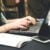 7 Tips for Students Dealing With Admissions Season Anxiety 4 Adult woman typing on a laptop at a desk with a smartphone and documents